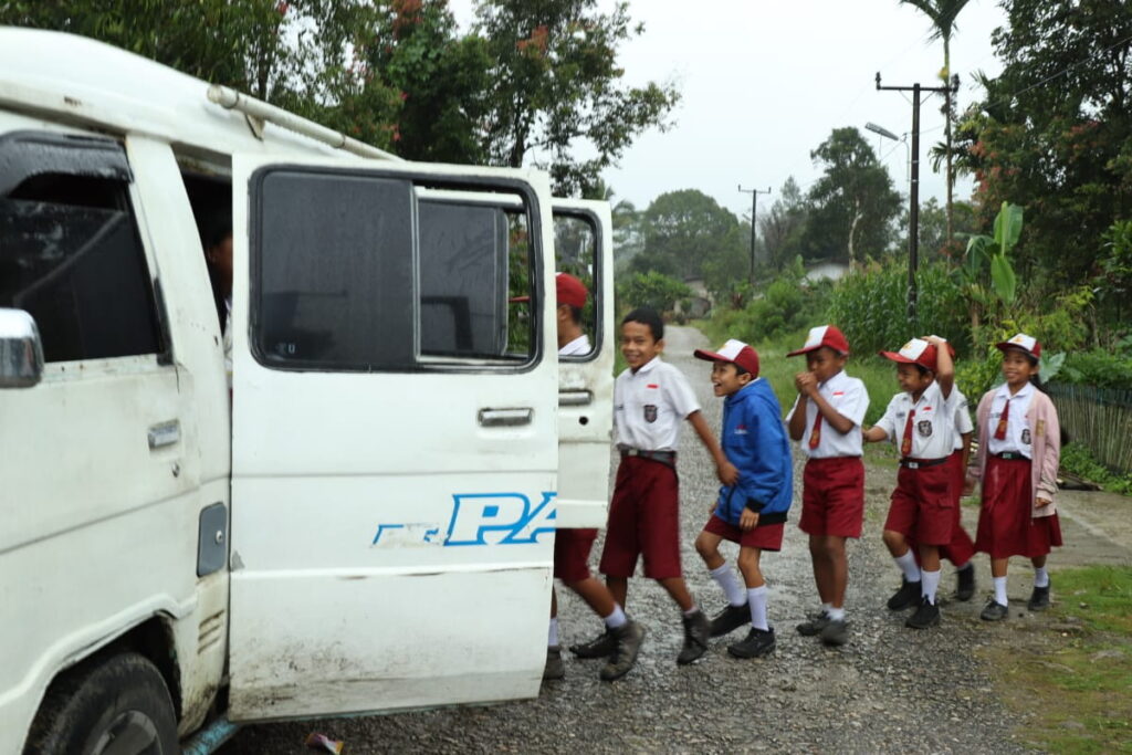 Sejumlah pelajar sekolah dasar di Dusun Kuta Kacib, Kecamatan Siempat Rube melambaikan tangan dari dalam bus sekolah, sesaat sebelum bus sekolah ini mengantar mereka menuju sekolah.